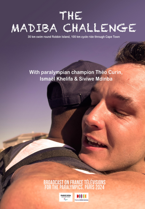 Poster for "The Madiba Challenge" shows two men embracing warmly. Text reads, "30 km swim round Robbin Island, 100 km cycle ride through Cape Town. With paralympian champion Théo Curin, Ismaël Khelifa & Siviwe Mdimba. Broadcast on France Télévisions for the Paralympics, Paris 2024.