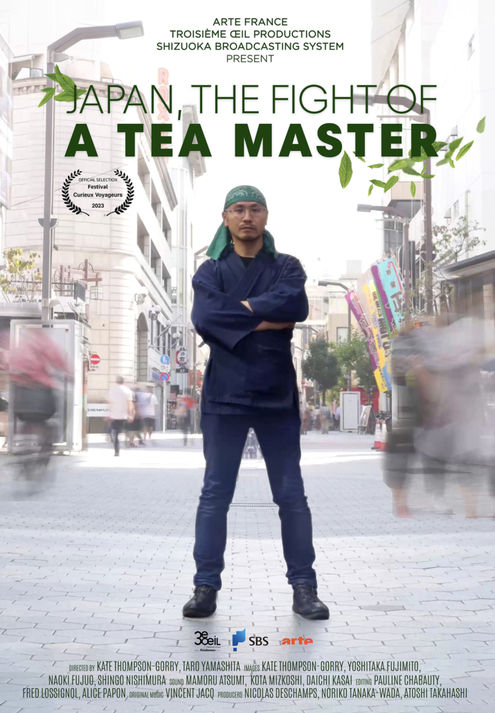 Film poster for "Japan, The Fight of a Tea Master" featuring the tea master standing confidently on a busy street, with a blurred crowd around him. He wears a headband, apron, and cross-armed pose amidst building facades and a clear sky in the background. Text includes film credits.